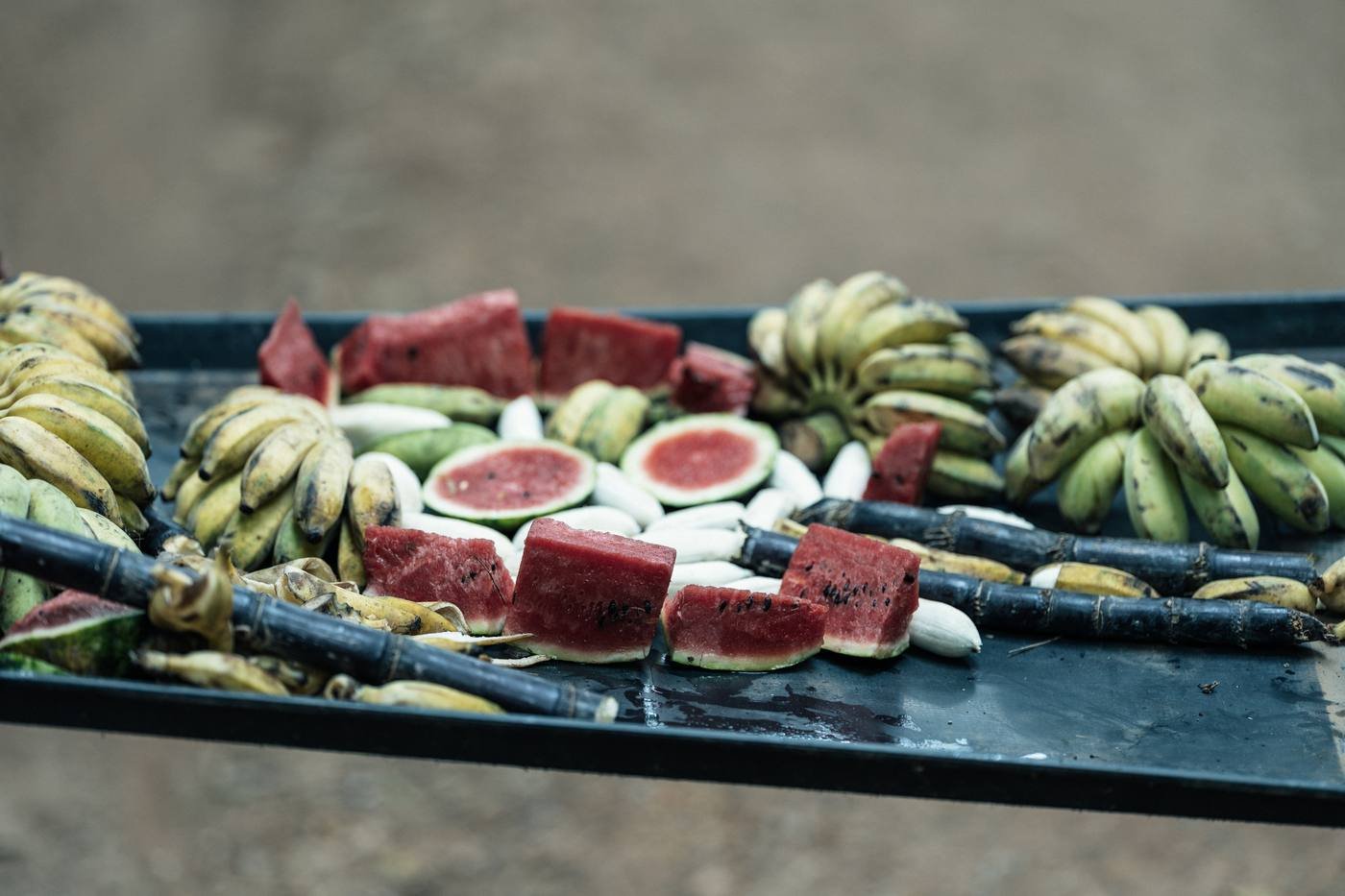 A tray of bananas, watermelon and sugarcane
